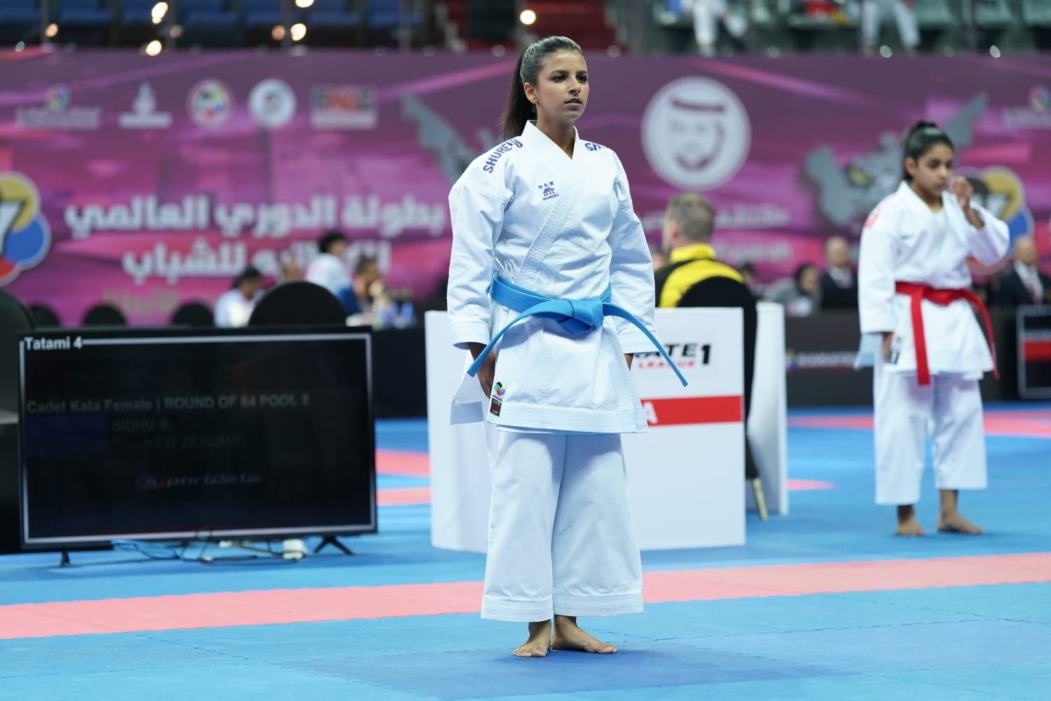 Savera Sidhu standing on the competition mat in a karate gi