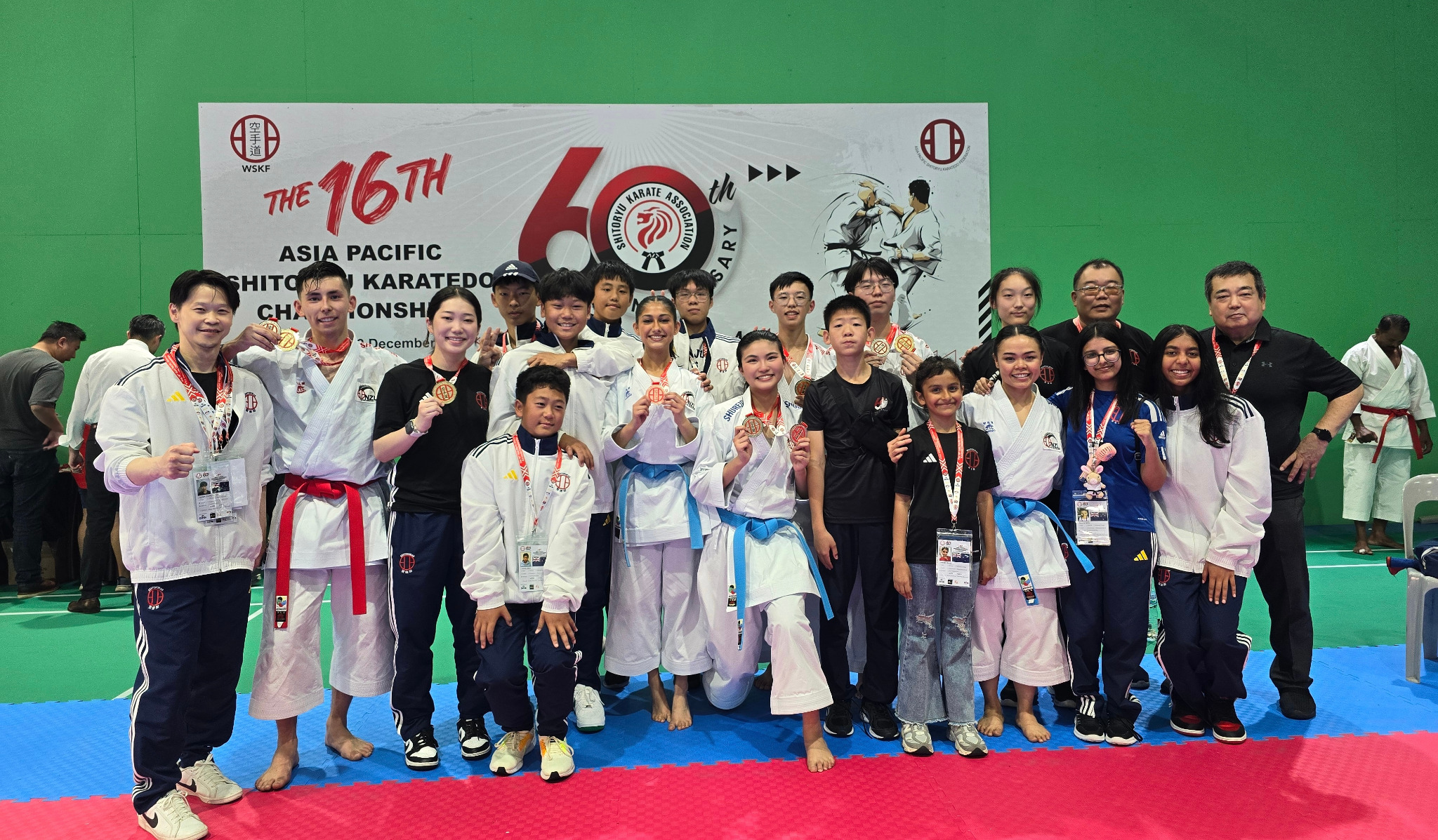 Karate competitors and coaches posing with medals at the 16th Asia Pacific Shitoryu Karatedo Championships
